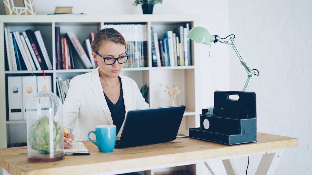 Woman working on a laptop at a desk.