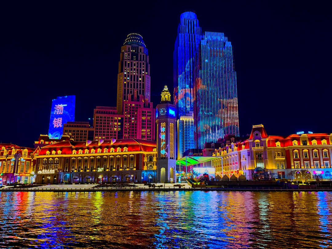 Colorful illuminated cityscape reflected in water at night.
