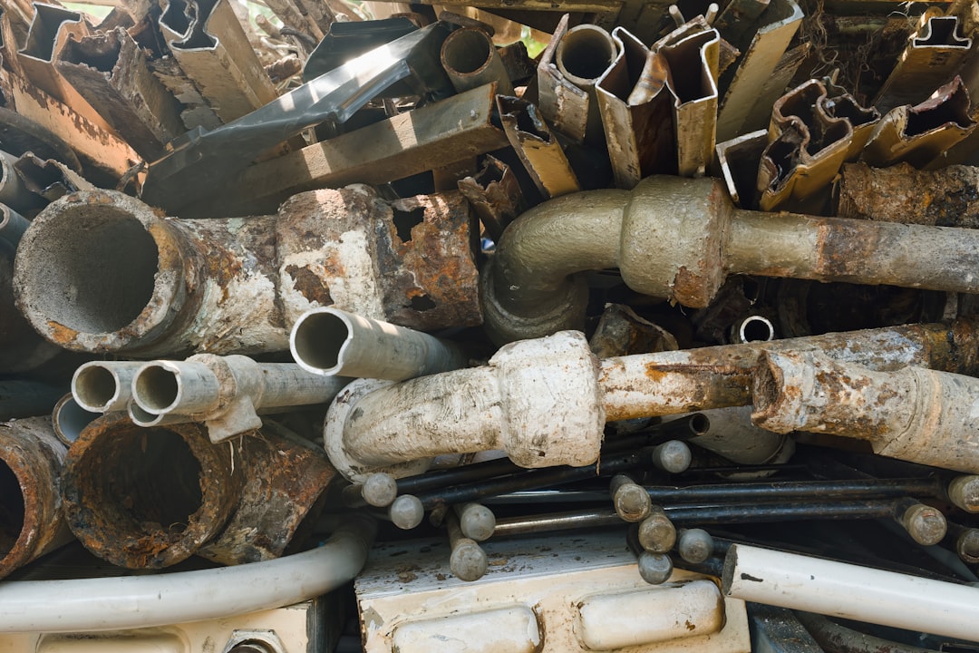 Pile of rusty metal pipes and plumbing parts