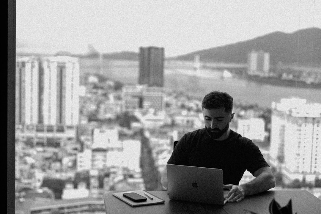 Man working on laptop with city view