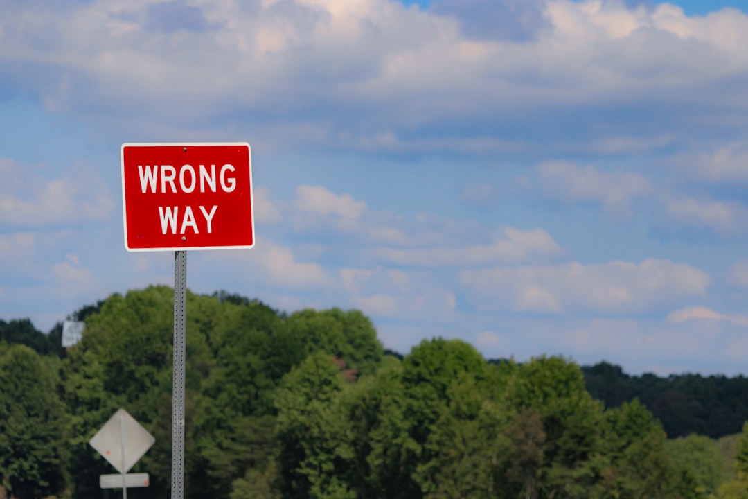 A red wrong way sign sitting on the side of a road