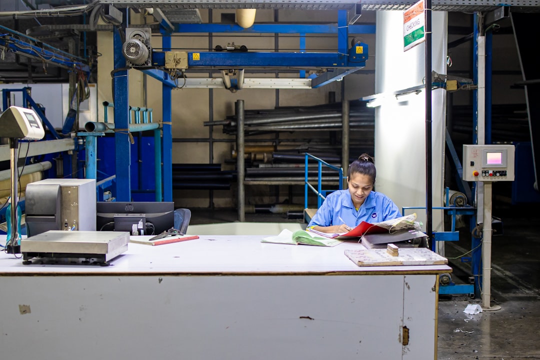 A woman works at a desk in a factory.