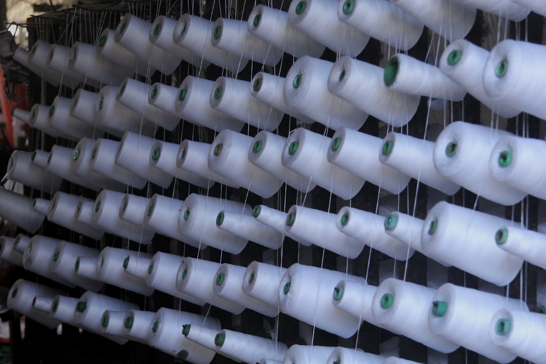 Rows of white spools of thread on a rack.