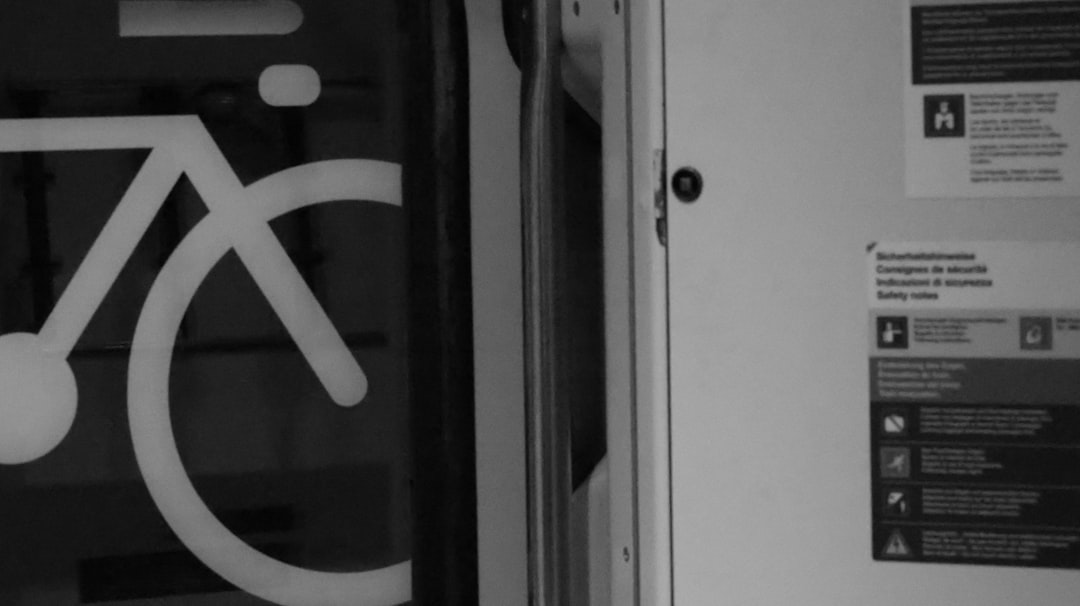 White bicycle symbol on dark background next to white door.