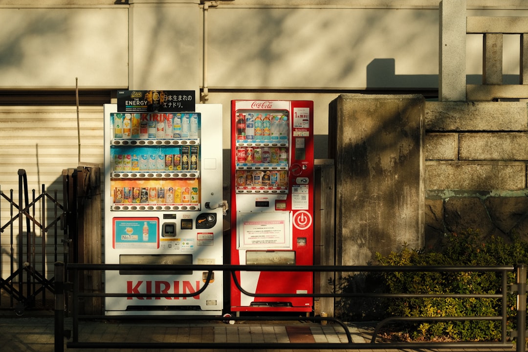 Two vending machines stand side-by-side on a wall.