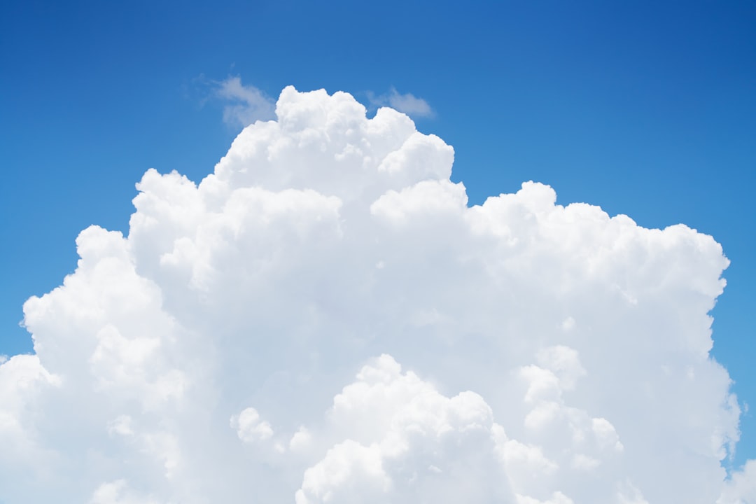 a large cloud in the sky with a blue sky background