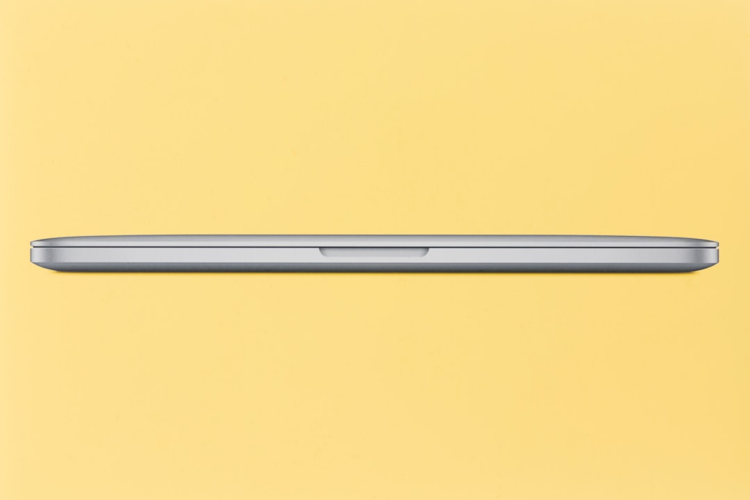 Closed silver laptop on a yellow background