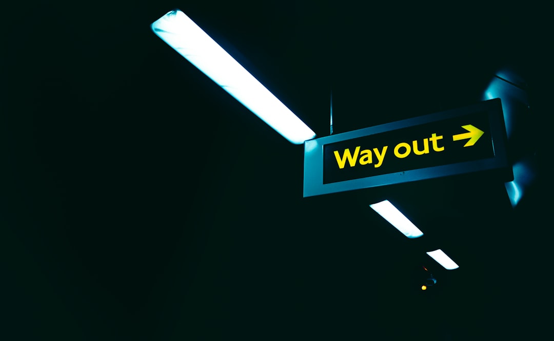 a black and yellow sign that says way out