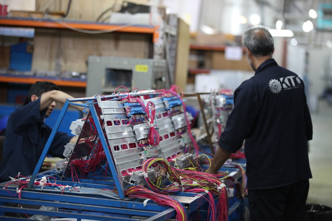 man in black shirt standing beside blue and red plastic crates