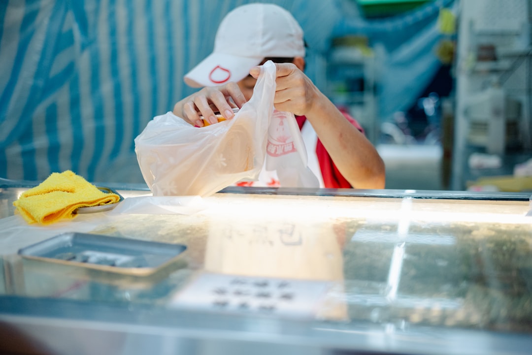 Vendor packing goods in a plastic bag.