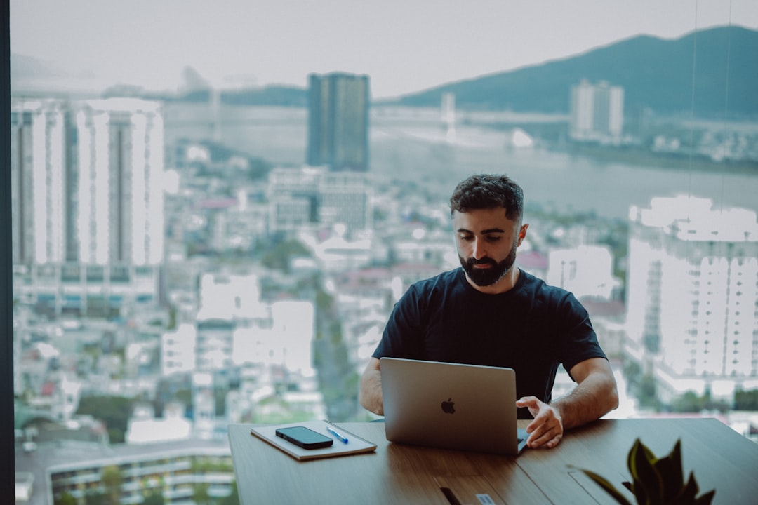 Man working on laptop with city view