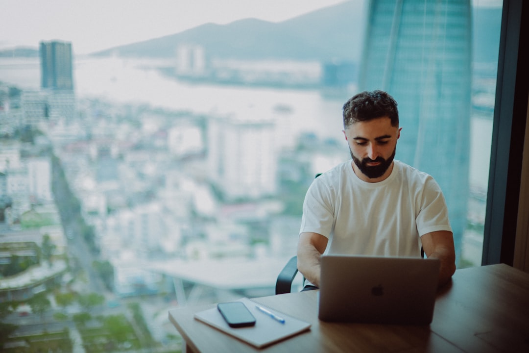 Man working on laptop with city view