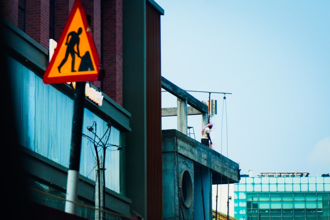 Construction sign on building with worker above