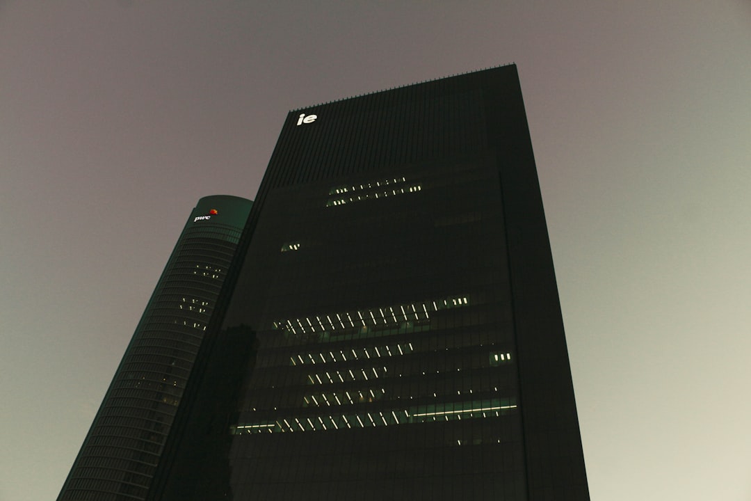 Two dark skyscrapers against a hazy sky.