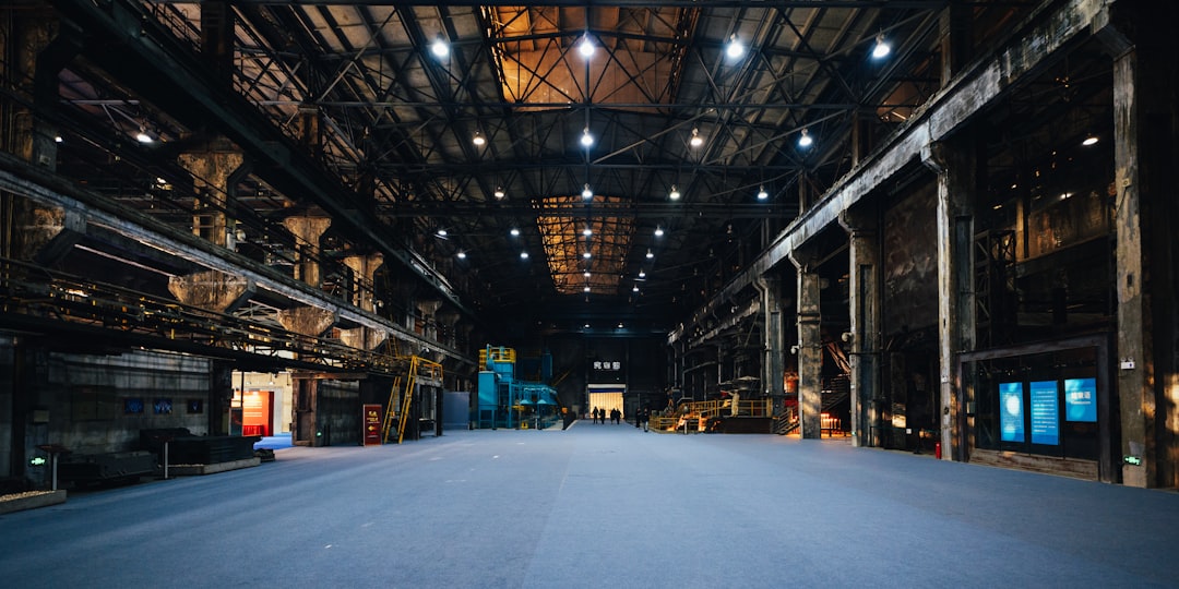 Vast empty industrial warehouse with overhead lighting