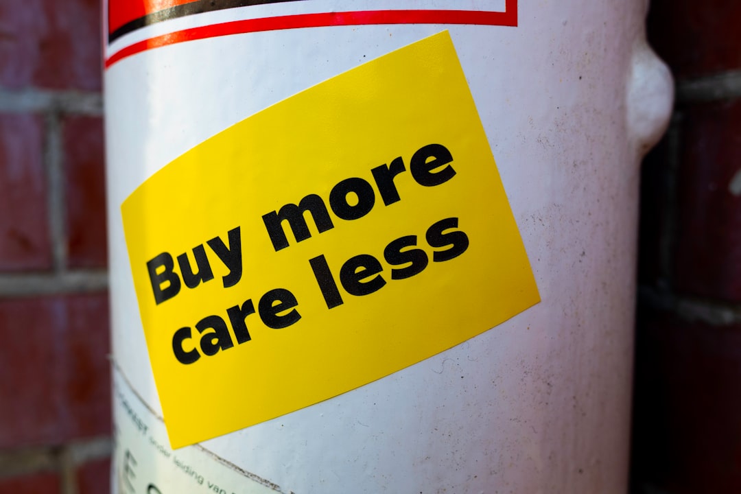 Yellow sticker with text 'buy more care less' on pole